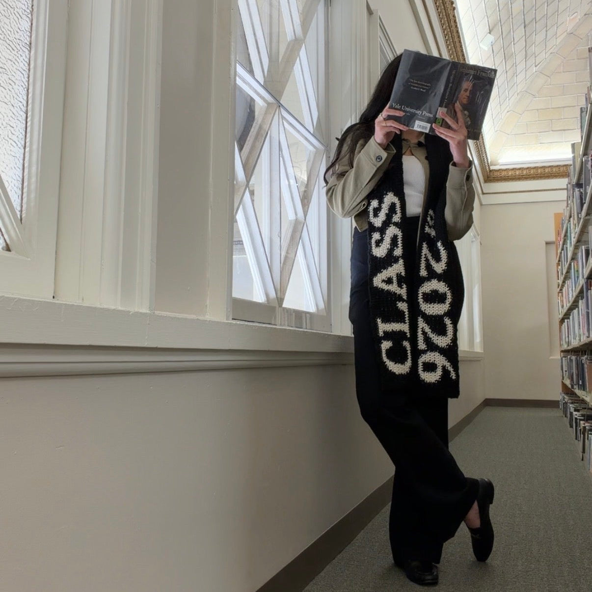 Person taking a photo of themselves in a library wearing a 'Class of 2026' sweatshirt.