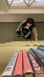 Person browsing books on a shelf in a library setting